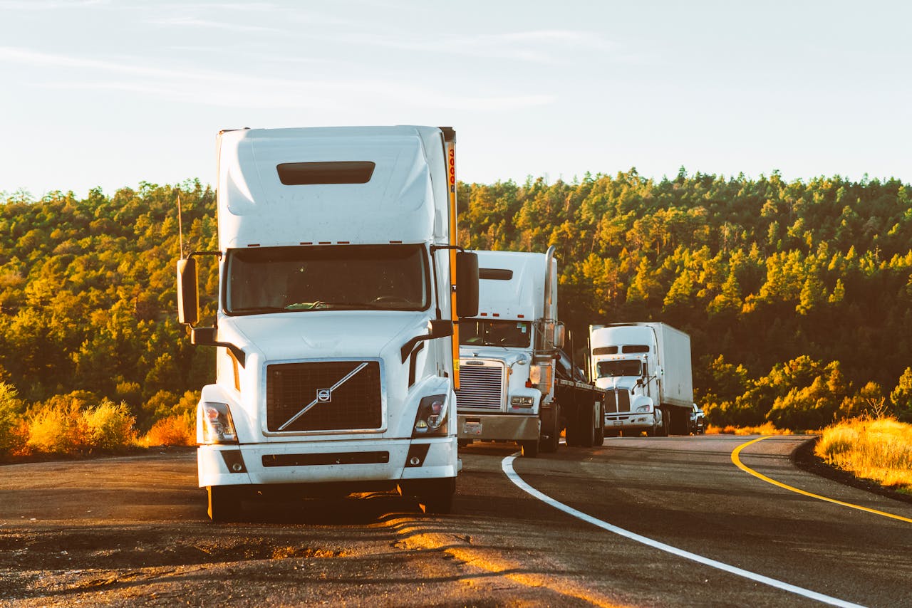 home-hero Three semi trucks driving on a highway through a forested landscape in Arizona.
